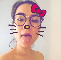 a woman wearing glasses with a cat face drawn on her forehead, making a funny face