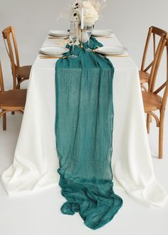 the table is set with white and green linens