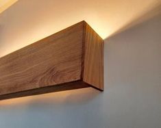 a wooden light fixture mounted to the side of a wall