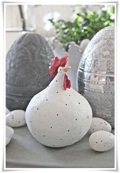 some eggs are sitting on a table with a rooster figurine