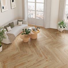 a living room filled with furniture and potted plants on top of wooden flooring