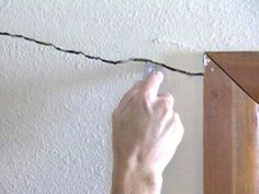 a person is working on an electrical wire that has been attached to the wall in front of them