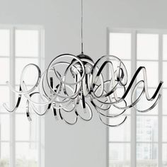 a modern chandelier hanging from the ceiling in an empty room with large windows