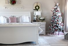 a white bed sitting next to a christmas tree