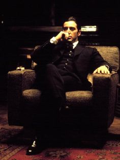 a man in a suit sitting on a chair