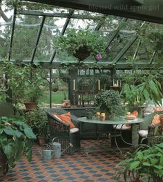 an outdoor dining area with potted plants in the center and tiled flooring on the other side