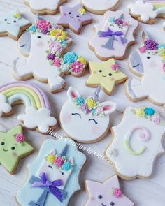 decorated cookies with unicorns, stars, and rainbow colors are on a white table