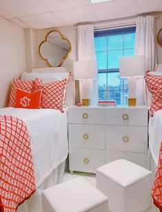 a bedroom with orange and white bedding, two nightstands and a mirror on the wall