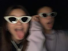 two people wearing white sunglasses making funny faces