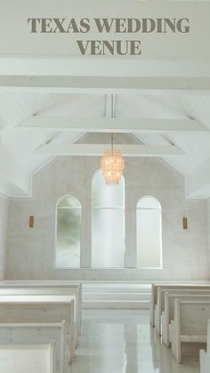 an empty church with white pews and stained glass windows