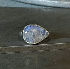 A pear-shaped, ethereal blue-flash Rainbow Moonstone gemstone is set in sterling silver and is perched atop a sterling silver band. Minimalist perfection. Size 8.5 Moonstone: 14x10mm Band: 3.5mm wide Ready to ship. Will arrive gift-boxed. My jewelry is handcrafted one piece at a time by me in my home studio in Portland, Oregon. If I can help you with any questions about this piece or any of my other products, please feel free to contact me: hello @ paulla.com PIN IT on PINTEREST FOLLOW on Instag Teardrop Moonstone Ring In Sterling Silver, Sterling Silver Teardrop Moonstone Ring, Teardrop Moonstone Gemstone Ring, Silver Teardrop Moonstone Ring, Silver Pear-shaped Moonstone Ring, Teardrop Moonstone Ring, Pear-shaped Moonstone Ring In Sterling Silver For Gift, Pear-shaped Moonstone Ring In Sterling Silver, Ethereal Blue