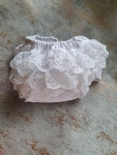 Beautiful all white baby frilly nappy/diaper cover.  This would look lovely worn with any little dress but especially for christenings or weddings, due to its traditional/vintage style. Made from 100% cotton material for the main cover with three rows of gorgeous delicate Nottingham Lace, giving the item a vintage/traditional look that never dates. The leg and waist cuffs are formed from super soft bias binding which encases the soft elastic. These are machine washable on a max 40 degree wash an White Cotton Bloomers With Ruffles, White Cotton Ruffled Bloomers, White Lace Ruffled Bottoms, White Lace Ruffled Petticoat, White Ruffled Lace Petticoat, White Lace Petticoat With Ruffles, Fitted White Diaper Cover For First Birthday, Fitted White Cotton Diaper Cover, Nottingham Lace