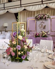 the table is set with flowers and place settings for guests to sit down at it