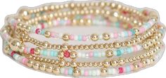 four bracelets with gold beads and pink, blue, and white beads on them