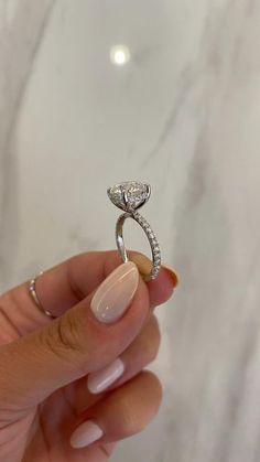 a person holding a diamond ring in their hand