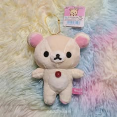 a white teddy bear keychain with a pink heart on it's chest