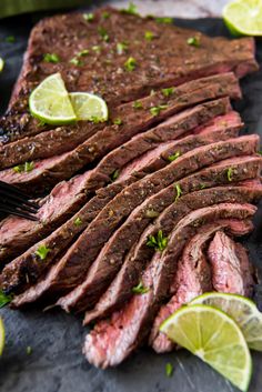 sliced flank steak with limes and seasoning on the side, ready to be served