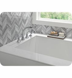 a bathroom sink with a white counter top next to a window