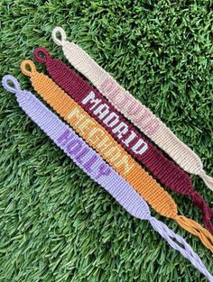 three crocheted lanyards with the words world peace on them sitting in grass