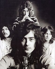 black and white photograph of three men with long hair sitting in front of each other