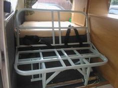 the interior of a camper van with its bed in position to be pushed up