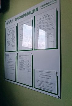 a bulletin board with several papers attached to it