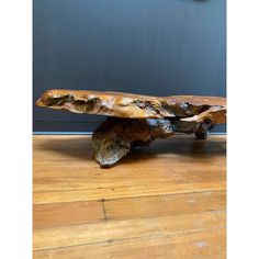 a piece of wood sitting on top of a wooden floor next to a wall with a clock