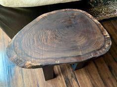 a wooden table sitting on top of a hard wood floor next to a white couch