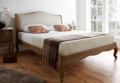 a bed sitting on top of a wooden floor next to a window