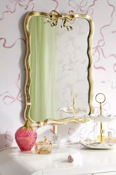 a white dresser with a mirror on top of it and a pink vase next to it