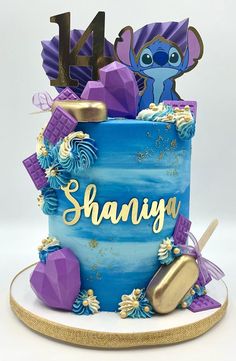 a blue and purple birthday cake with the name shaniya on it's side