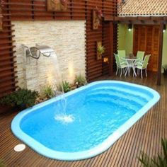 an above ground swimming pool in the middle of a wooden decked area with chairs around it