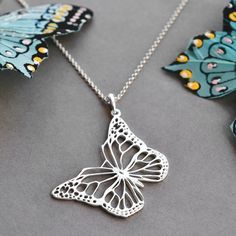 Our gorgeous Sterling Silver Monarch Butterfly Necklace captures the beauty of this fantastic butterfly in stunning detail. A truly regal piece of jewellery. This wonderful sterling silver necklace uses a filigree design to replicate the patterning of a Monarch butterfly which is often described as the most beautiful butterfly of all. Butterfly jewellery is great for symbolising change and has been a firm favourite for years. All Martha Jackson jewellery comes in a gift box with a small gift card for you to write a message on.  made from: Sterling Silver. Keep clean with an anti tarnish cloth. dimensions: Pendant 3cm x4cm Add on initial letter charms approximately 1cm. Necklace Length -Short 35-40cm, Standard 40-45cm, 50cm, Long 61cm and Extra long 76cm. Elegant Silver Butterfly Necklace With Charm, Butterfly-shaped Filigree Jewelry Gift, Butterfly Filigree Jewelry Gift, Butterfly Shaped Filigree Jewelry Gift, Butterfly Filigree Jewelry As A Gift, Elegant Butterfly Filigree Jewelry, Elegant Butterfly Shaped Filigree Jewelry, Silver Engraved Butterfly Jewelry, Elegant Sterling Silver Butterfly Necklace