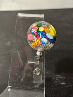 Super fun handmade resin bubble with clear background attach to a badge reel.  This listing is for a single badge reel. The resin bubble:  1.5" diameter (back) and 1.25" diameter (front) x .375" deep with 3-5 generic colorful gelcaps, capsules, caplets and sprinkles. All bubbles will come with a white retractable ID badge holder badge reel with a swivel alligator clip already attached to the resin pill bubble with a 1 inch 3M double sided adhesive dot.  The white badge reel retractable cord retracts to 23.6". Our art resin is BPA free and food safe and can be used on coasters, cutting boards, tumblers, and other kitchen items. High quality, non-toxic, art resin with zero VOCs and odor free is always used. All epoxy resin may yellow over time, to avoid this please limit direct sunlight expo Pill Badge Reel, Novelty Multicolor Badge Reel For Hobby, Novelty Multicolor Badge Reel, Badge Holders Diy, Resin Bubble, Chill Pill, Clean Towels, Retractable Id Badge Holder, Retractable Badge Holder