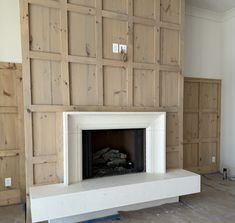 a fireplace in a room with wooden paneling on the walls