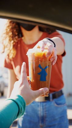 a person holding up a drink in their hand