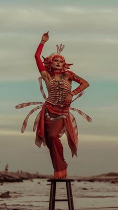 a woman is standing on a stool with her arms in the air while wearing a skeleton costume