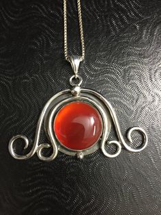 Inspired by art nouveau and bohemian magic, along with the ancient feel of the Celts, this design is hand-forged in sterling silver featuring a 20mm glowing red paua shell, as shown in the image, or you can choose from the drop down menu. The interior between the scroll work is antiqued for a contrasting effect of highly polished silver and an 'aged' effect. This piece is approximately 1.5 inches from top to bottom and 2 inches in width and forged from 12 guage sterling wire so it's got weight a Art Nouveau Jewelry With Artistic Design For Gift, Handmade Art Nouveau Jewelry, Art Nouveau Sterling Silver Pendant, Art Nouveau Nickel-free Jewelry As A Gift, Vintage Round Jewelry With Artistic Design, Nickel-free Art Nouveau Jewelry For Gifts, Nickel-free Art Nouveau Jewelry Gift, Art Nouveau Nickel-free Jewelry Gift, Antique Sterling Silver Hand Forged Necklaces