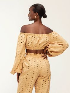 Step into style with our Naka midriff top, boasting chic and exaggerated sleeves. Crafted for comfort with elasticized features throughout, this crop off-the-shoulder piece is perfect for pairing with our Leer Nar Pants, ensuring you're ready for your next destination in effortless elegance. Handcrafted in our small atelier in Dakar, Senegal, this top blends intricate embroidery with sustainable 100% cotton for a timeless addition to your wardrobe. Crop off-the-shoulder top Elasticized sleeves E Summer Off-shoulder Top With Blouson Sleeves, Summer Long Sleeve Off-shoulder Top With Blouson Sleeves, Summer Cropped Off-shoulder Top For Day Out, Trendy Off-shoulder Crop Top For Brunch, Chic Bandeau Crop Top For Brunch, Spring Off-shoulder Top With Blouson Sleeves, Chic Spring Off-shoulder Top With Blouson Sleeves, Chic Off-shoulder Top With Blouson Sleeves For Spring, Off-shoulder Crop Top For Spring Day Out