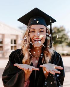 a woman wearing a graduation cap and gown throwing confetti in the air with her hands