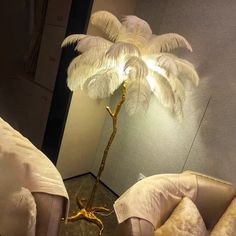 a lamp that is on top of a table next to two chairs and a palm tree