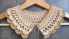 a crocheted collar on a wooden hanger