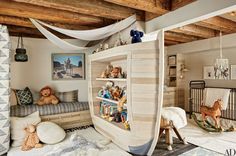 a child's room with stuffed animals on the shelves and toys in the crib