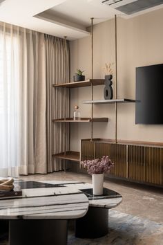 a living room filled with furniture and a flat screen tv mounted on a wall next to a window