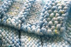 a close up view of a blue and white knitted blanket