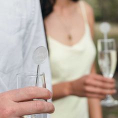 a man and woman holding wine glasses in their hands with the bride's name etched on them