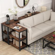 a living room with a couch, coffee table and mirror on the wall above it