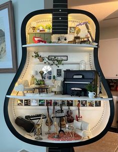 the inside of a guitar shaped shelf with pictures and other items on it's sides