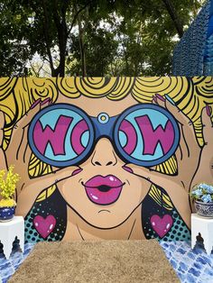 a large mural on the side of a building with woman's face wearing sunglasses