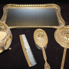 an assortment of gold colored items including a mirror and comb